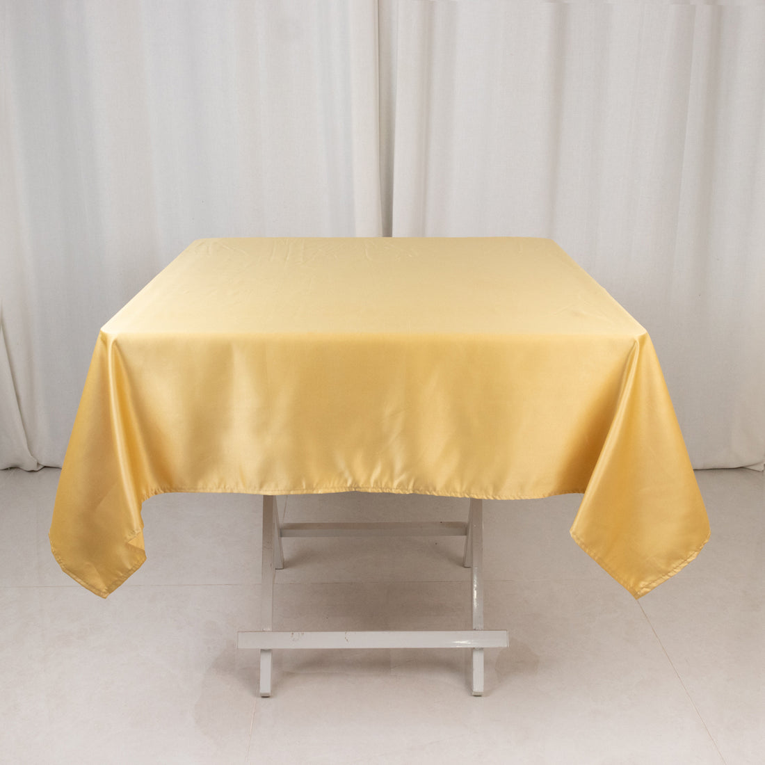Yellow satin tablecloth on a folding table.