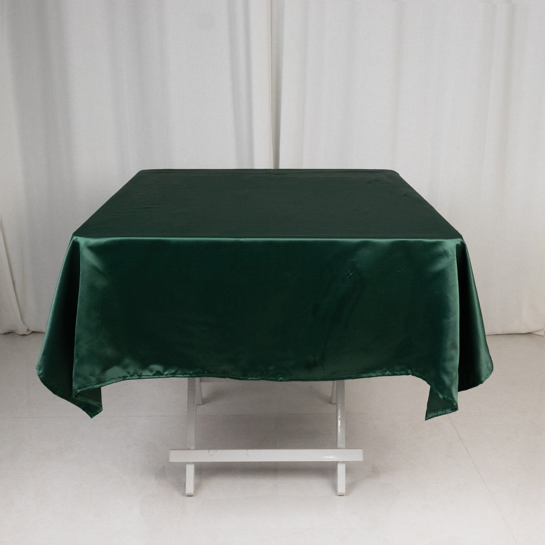 Green satin tablecloth on a white backdrop