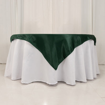 Green satin table runner on a white tablecloth.