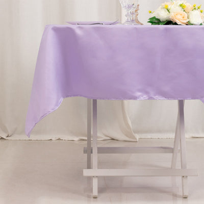 Lavender tablecloth draped elegantly over a white table with floral centerpiece.