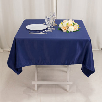 Navy tablecloth set with plates and glasses on a dining table.