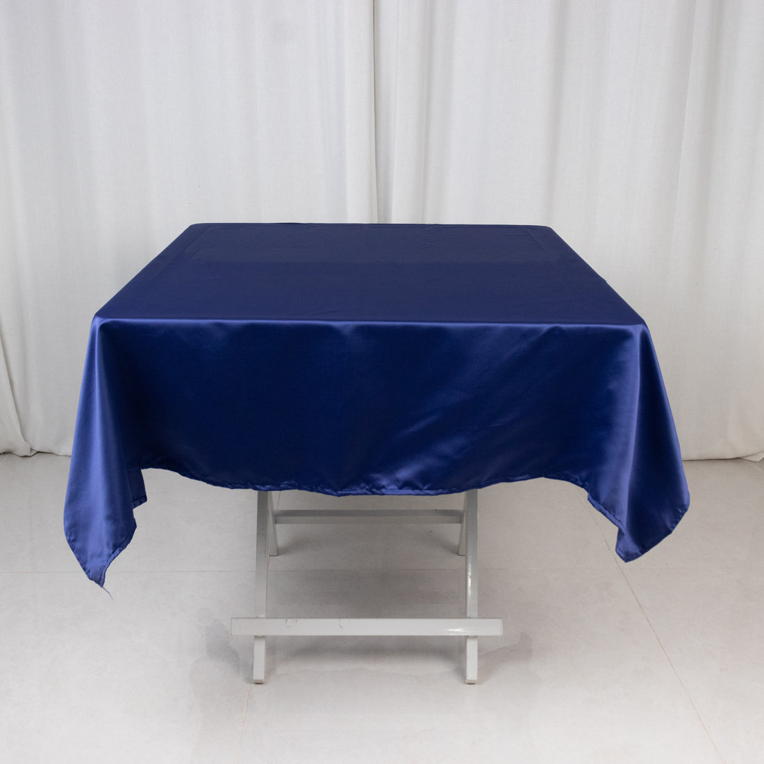 Navy blue satin tablecloth draped over a folding table