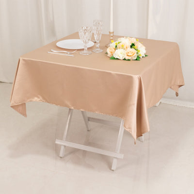 Beige satin tablecloth draped over a folding table set for dining.