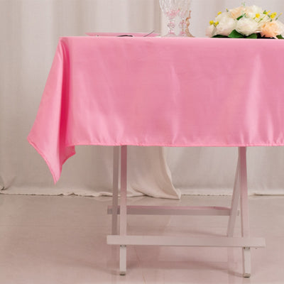 Pink tablecloth draped over a white table in a soft, elegant setting.