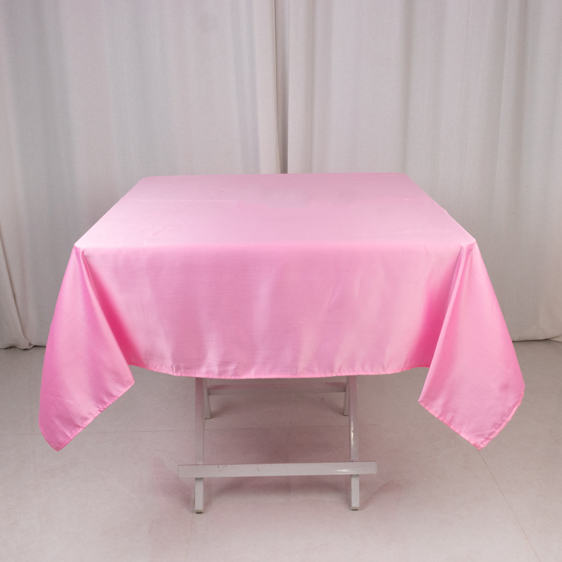 Pink satin tablecloth draped over a folding table