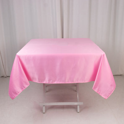 Pink satin tablecloth draped over a folding table