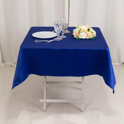 Navy blue tablecloth set on a table with dinnerware and flowers