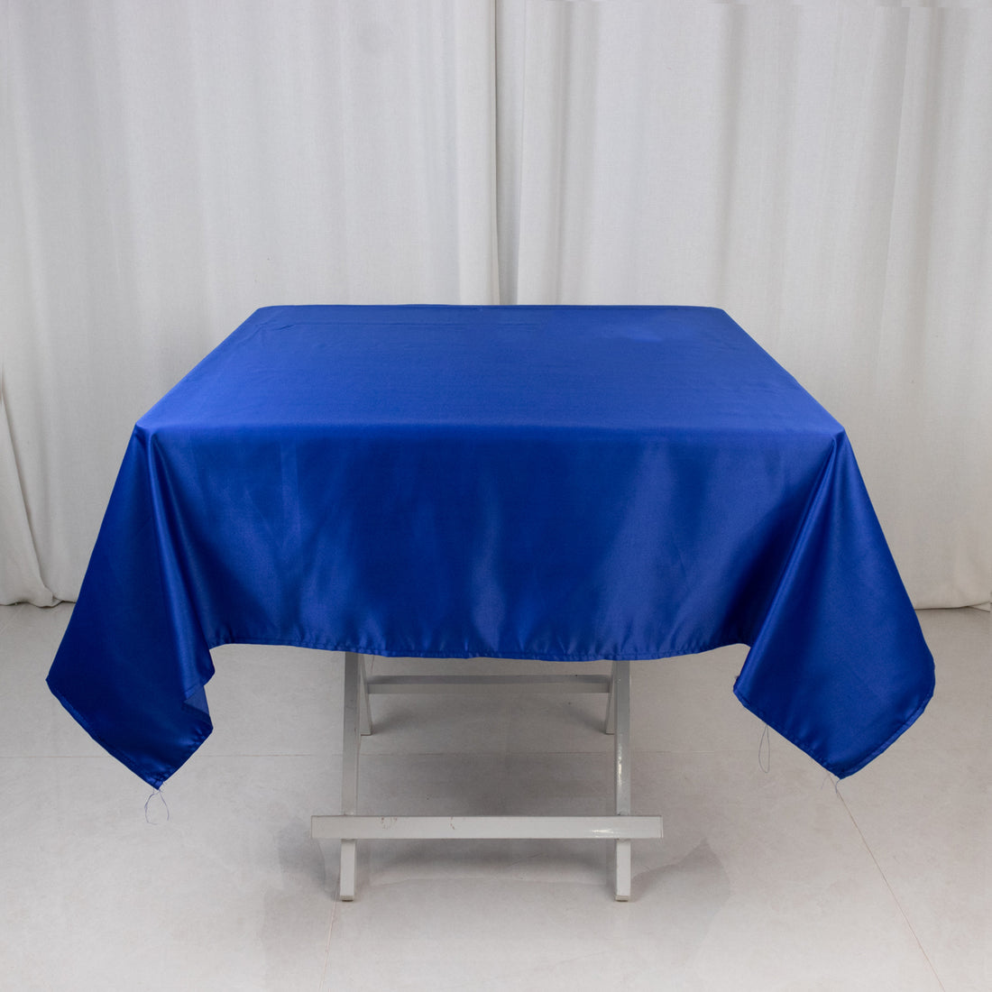 Blue satin tablecloth draped over a wooden table.