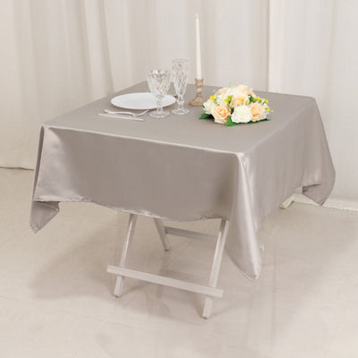 Elegant gray tablecloth set for a romantic dining experience with flowers and glassware.