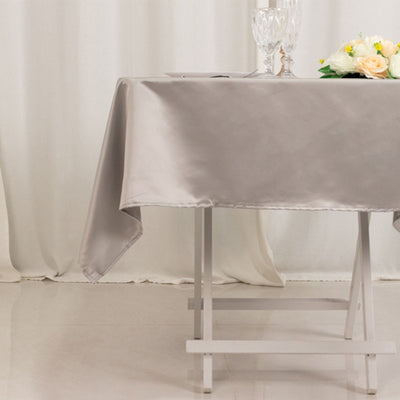 Elegant silver tablecloth draped over a folding table with decorative items.
