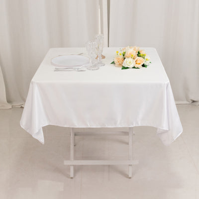 Elegant white table set with flowers and crystal glassware.