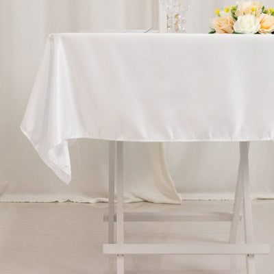 Elegant white tablecloth draped over a wooden table, adorned with floral centerpiece.