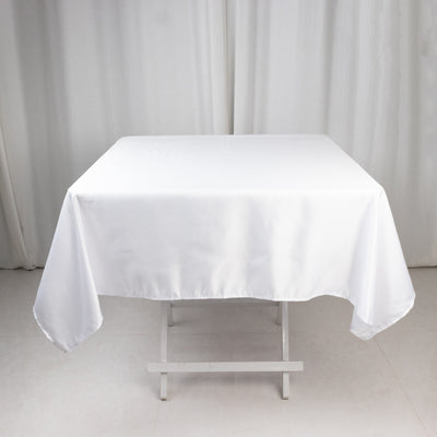 White tablecloth draped over a table in a studio setting.