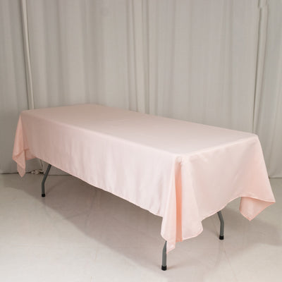 Pink tablecloth draped over a table on a plain backdrop.