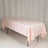 Pink tablecloth draped over a table on a plain backdrop.