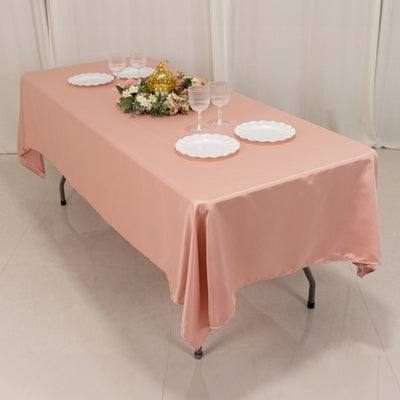 Pink tablecloth draped over a table set for an elegant dining occasion.