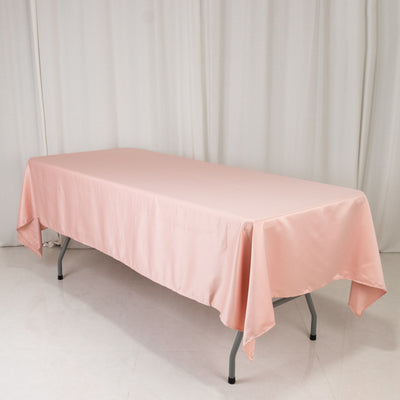 Pink tablecloth draped over a folding table in a studio setting.