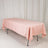 Pink tablecloth draped over a folding table in a studio setting.