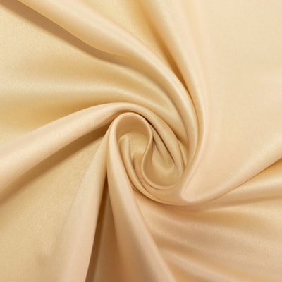 Satin fabric in soft peach color, elegantly draped and textured.