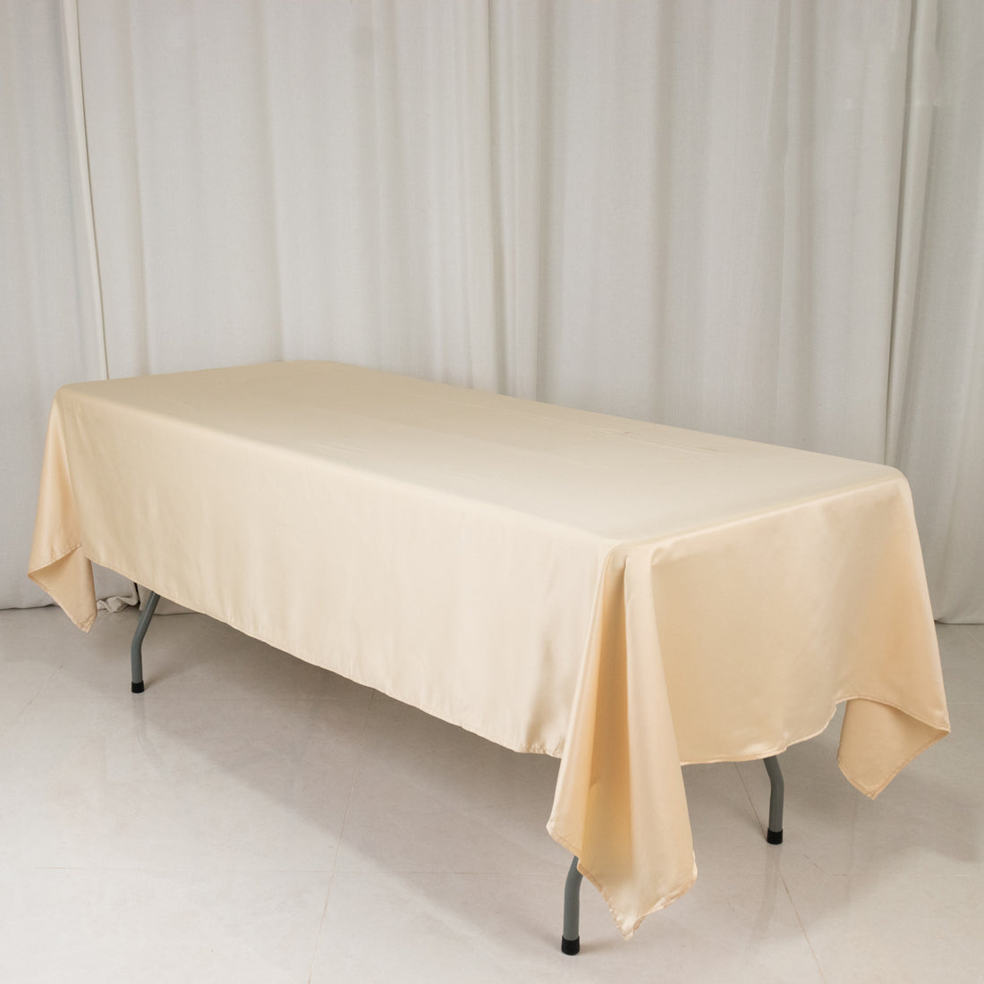 Beige tablecloth draped over a rectangular table in a studio setting.