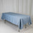 Blue satin tablecloth draped over a table on a plain backdrop.