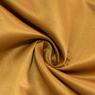 Golden satin fabric swirl, showcasing smooth texture and rich color.