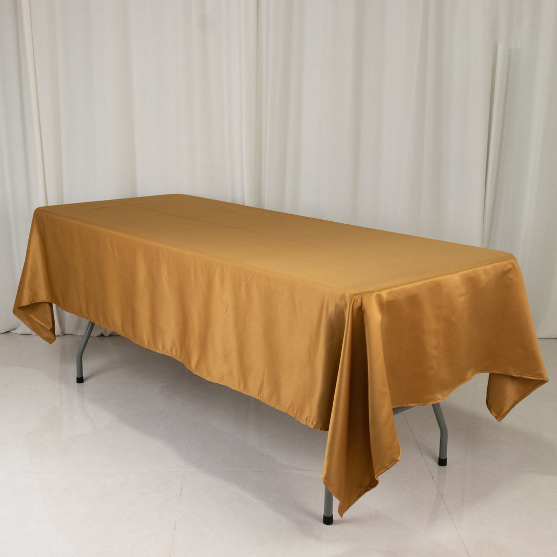 Golden tablecloth draped over a table in a studio setting.