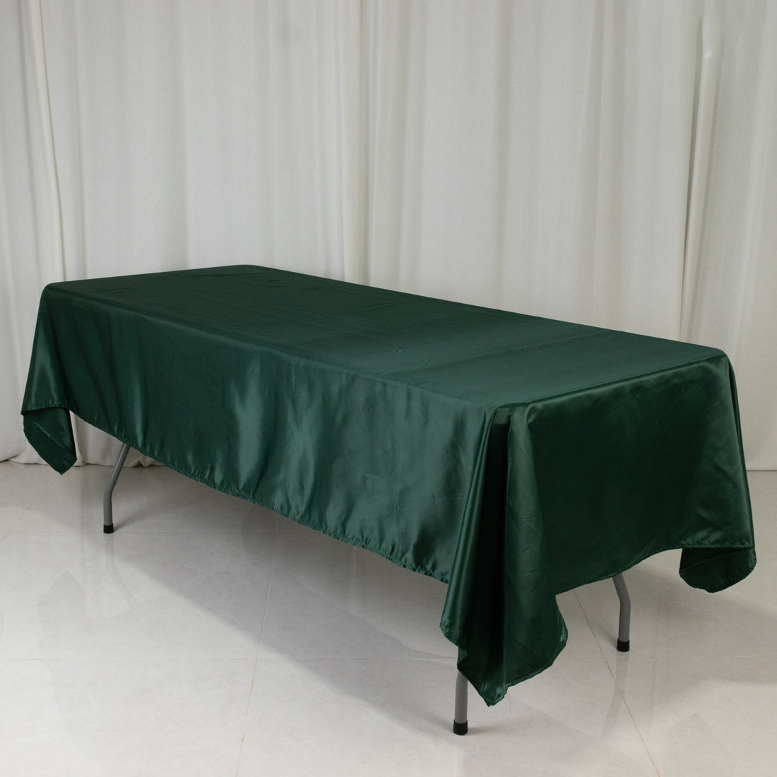 Green satin tablecloth draped over a rectangular table