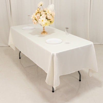 Elegant white dining table set for an event with floral centerpiece.