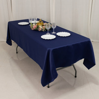 Navy tablecloth on a table set with plates and glasses, adorned with flowers.