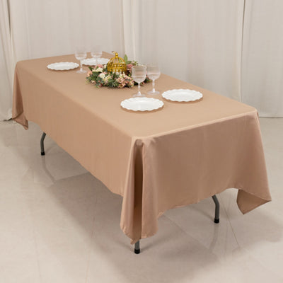 Elegant beige tablecloth draped over a dining table with decorative elements.