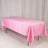 Pink tablecloth draped over a folding table in a studio setting.