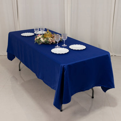 Blue tablecloth draped over a table set with plates and glasses.