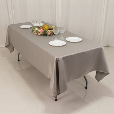 Elegant gray tablecloth draped over a table with dinnerware and floral centerpiece.