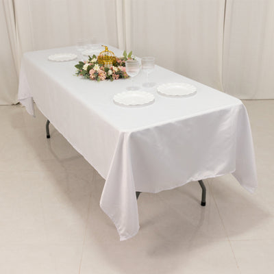 White table set with plates and floral centerpiece, ideal for events.