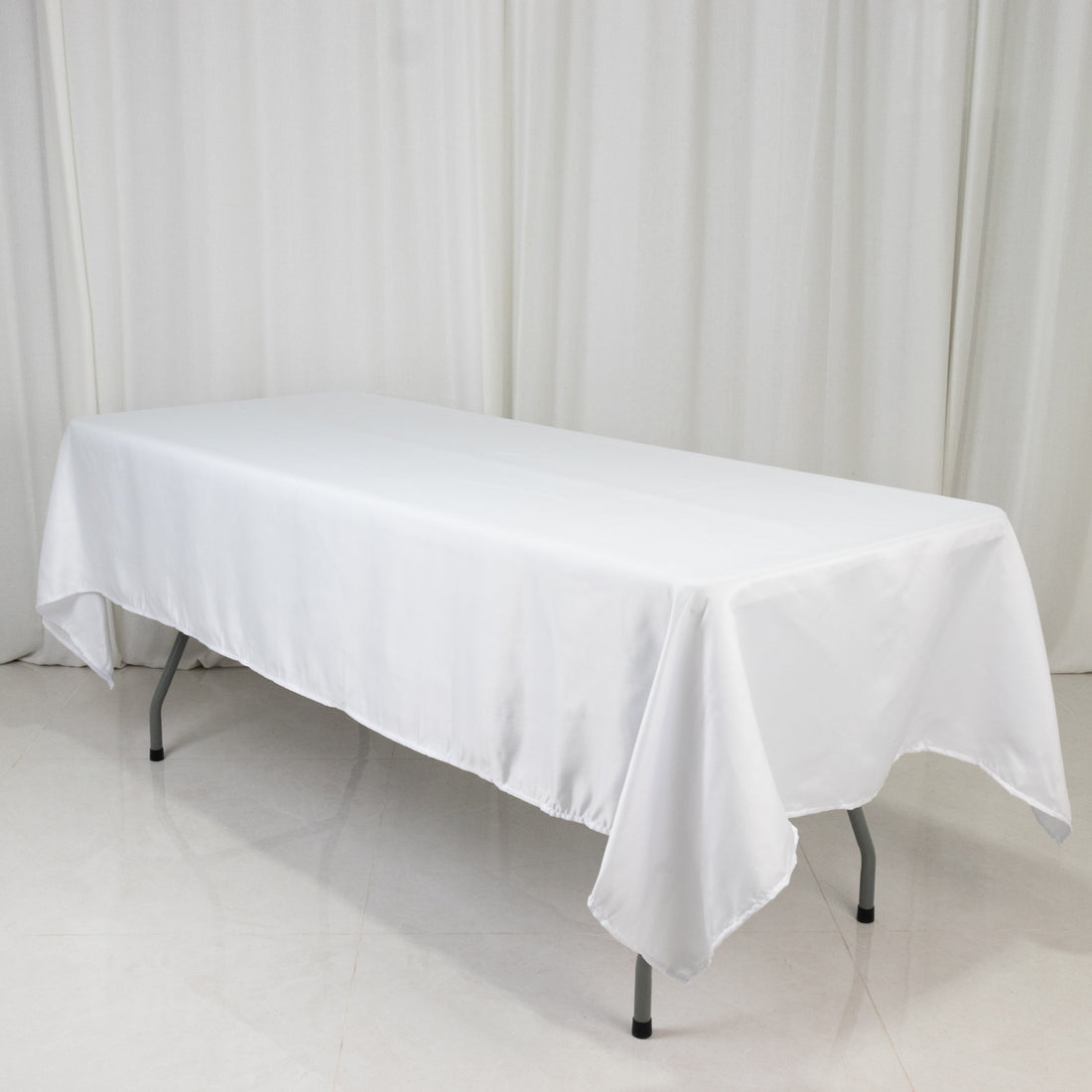 White tablecloth on a folding table against a light backdrop