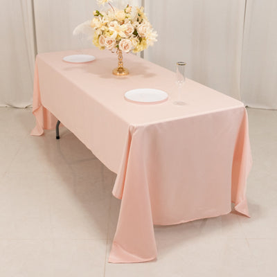 Pink tablecloth draped over a table, styled with flowers and dinnerware.