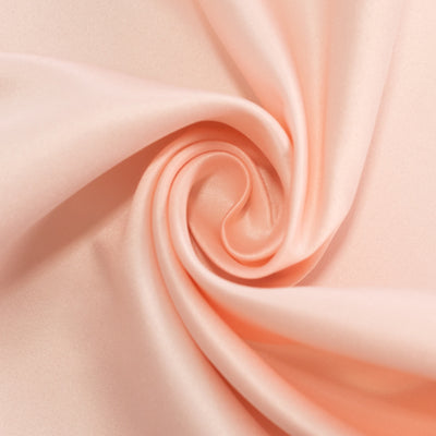 Peach satin fabric in a swirling pattern.