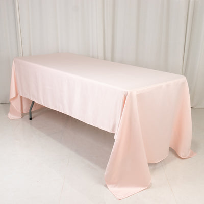 Pink tablecloth draped over a folding table in a studio setting.