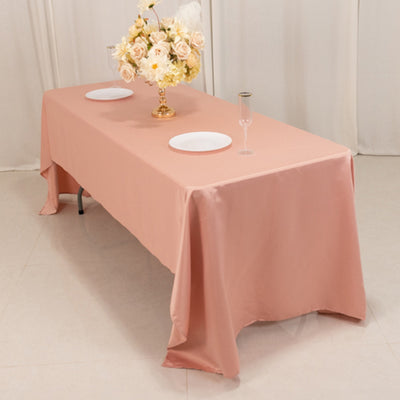 Elegant pink tablecloth draped over a dining table with decorative floral centerpiece.