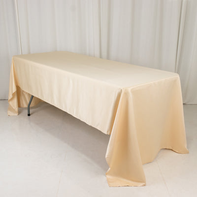 Beige tablecloth draped over a folding table in a studio setting.