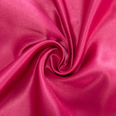 Smooth pink satin fabric swirling in a circular pattern.