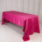 Pink satin tablecloth draped over a table in a studio setting.