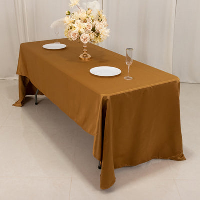 Brown tablecloth draped over a table set with plates and glasses.