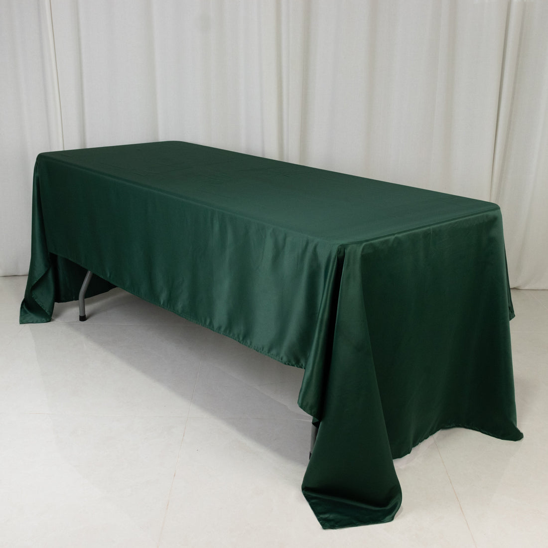 Green tablecloth draped over a table in a studio setting.