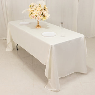 Elegant white tablecloth with floral centerpiece on a banquet table.
