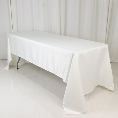White table covered with a plain tablecloth in a studio setting.