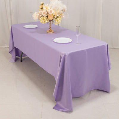 Purple tablecloth draped over a table with decorative flowers and dishes.