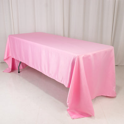 Pink tablecloth draped over a table in a studio setting.