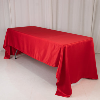 Red tablecloth draped over a rectangular table in a studio setting.